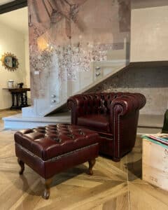 Piccola poltrona Chesterfield rossa vintage in pelle con poggiapiedi