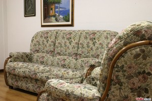 Salotto classico con rifinizioni in legno e tessuto floreale