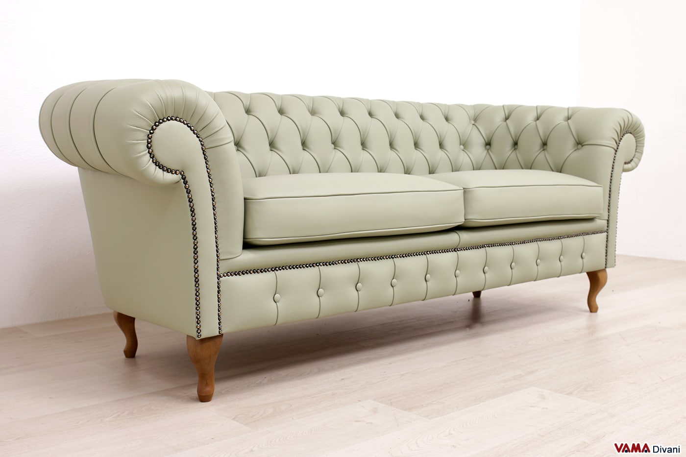 Sofà stile inglese verde con piedini Chippendale e lavorazione capitonné vista prospettica