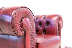 Poltrona Chesterfield con bracciolo plissettato in pelle rossa invecchiata