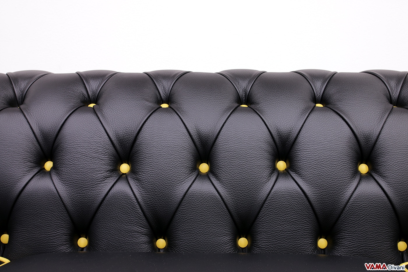 Schienale del divano Chesterfield con lavorazione capitonné in pelle nera e bottoni gialli personalizzati