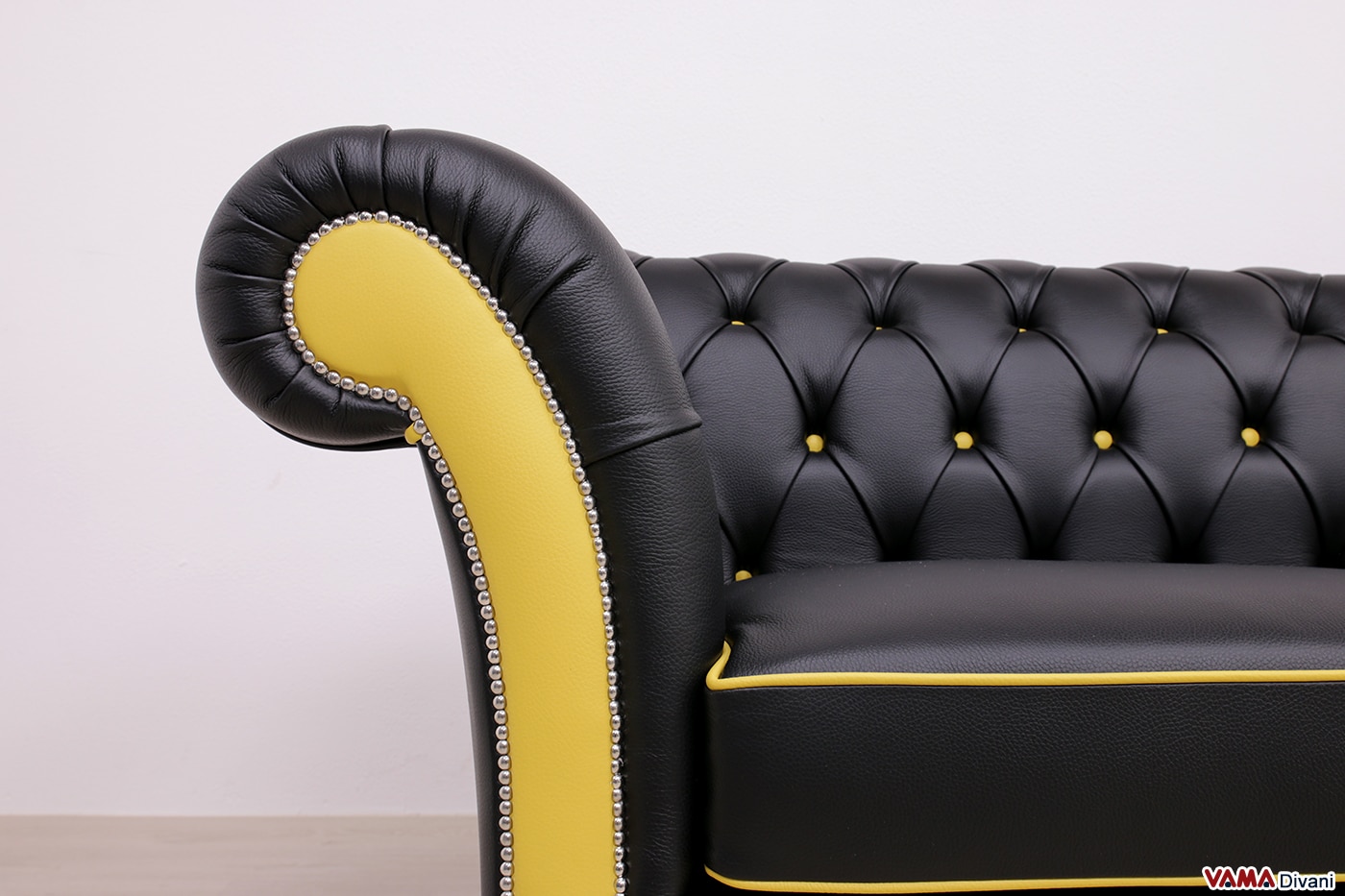 Bracciolo del divano Chesterfield in pelle nera con dettagli gialli e chiodatura artigianale