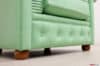 Particolare dei piedini sferici in legno finitura noce della poltrona Chesterfield su misura verde menta chiaro