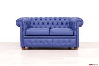 Divano Chesterfield piccolo 2 posti in pelle blu zaffiro opaco, con schienale capitonné e bracciolo lavorato a pieghe artigianali.