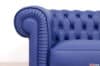 Dettaglio del bracciolo del divano Chesterfield piccolo in pelle blu zaffiro opaco con plissettatura artigianale.